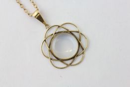 A MOONSTONE PENDANT ON AN UNMARKED YELLOW METAL CHAIN, THE CIRCULAR STONE IN A LOOPED SETTING,