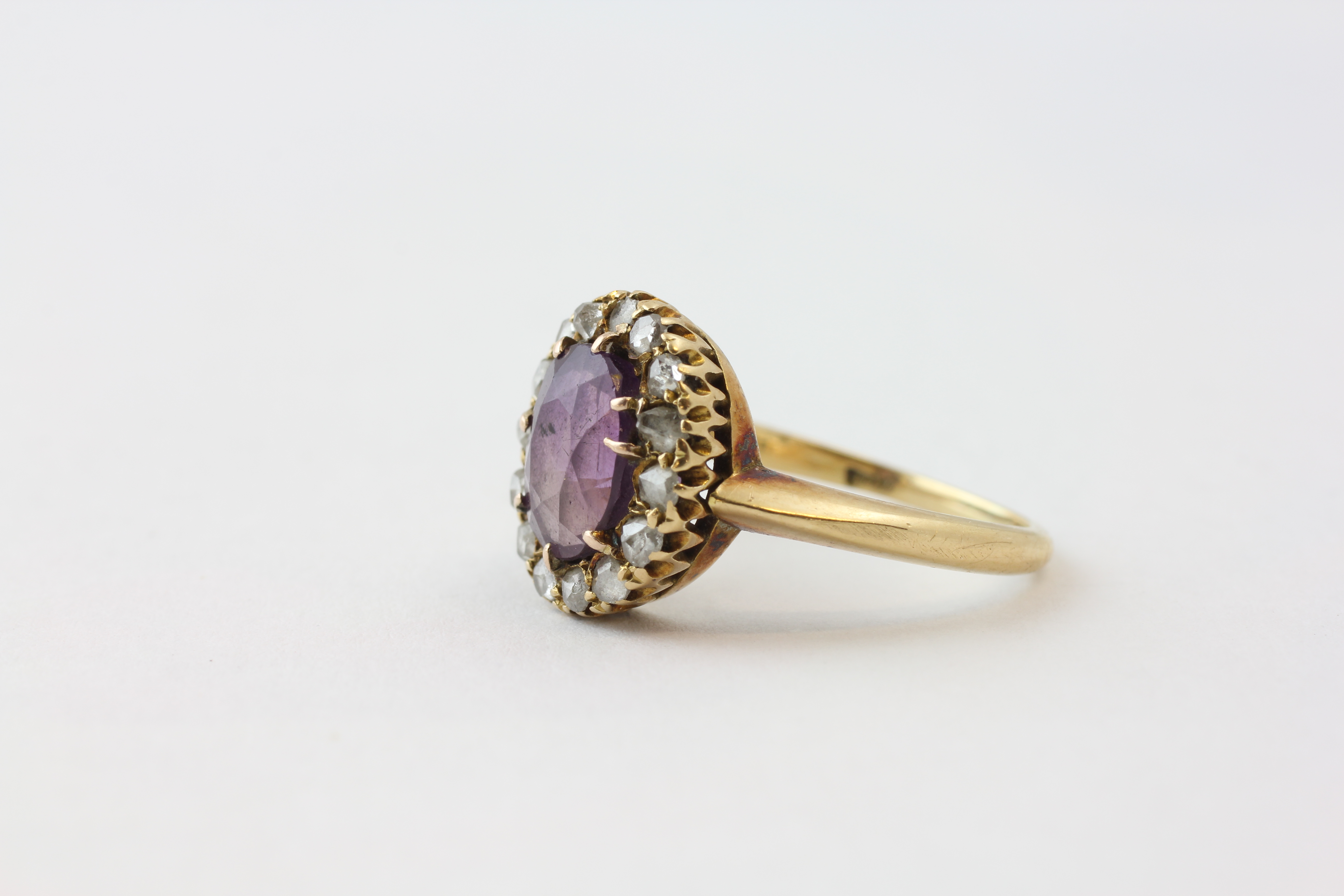 AN AMETHYST RING, THE OVAL STONE SURROUNDED BY FIFTEEN SMALL DIAMONDS SET IN YELLOW METAL, - Image 3 of 6