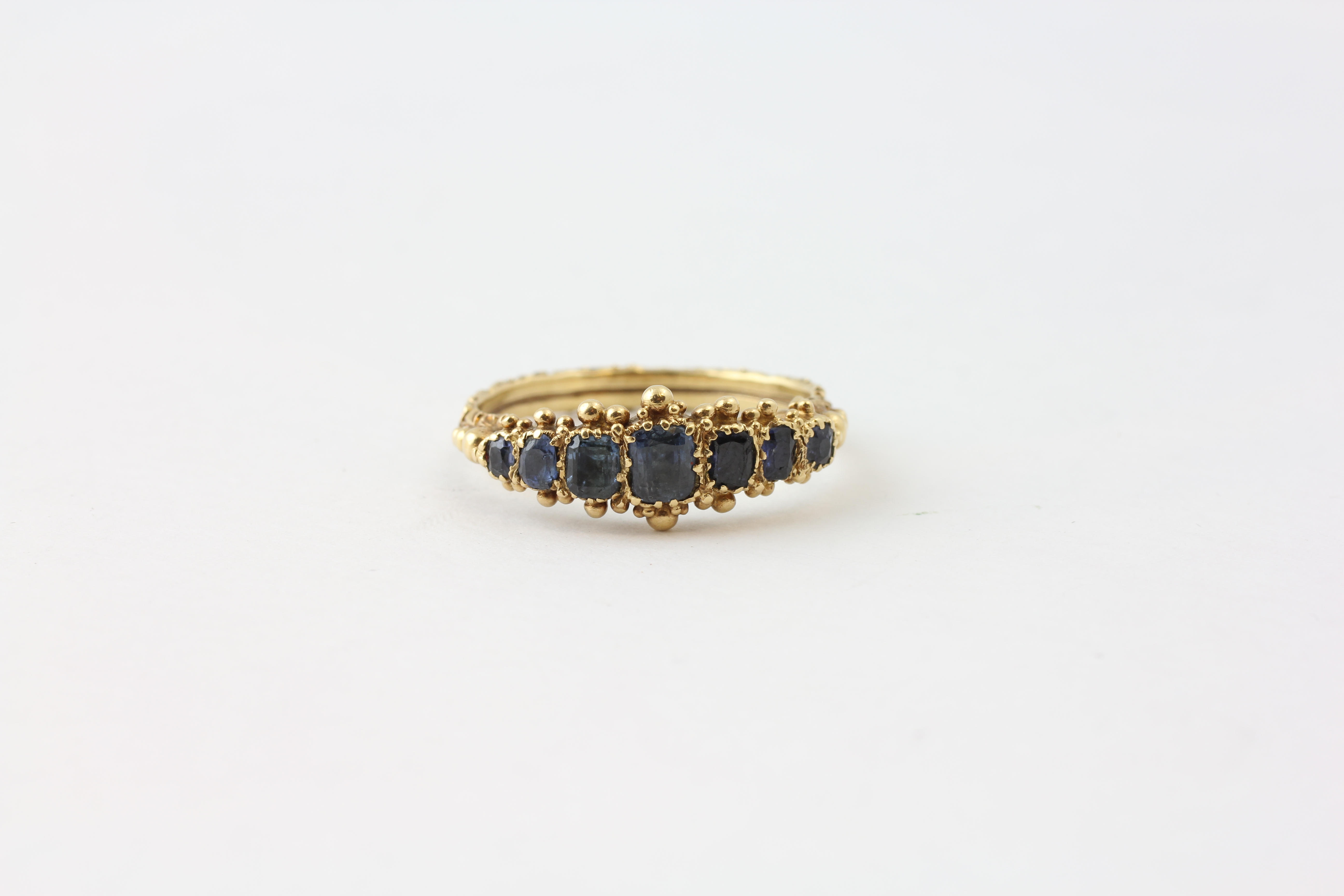 A SAPPHIRE RING, FIVE GRADUATED STONES, CLAW SET IN UNMARKED GOLD, THE LARGEST STONE APPROX.