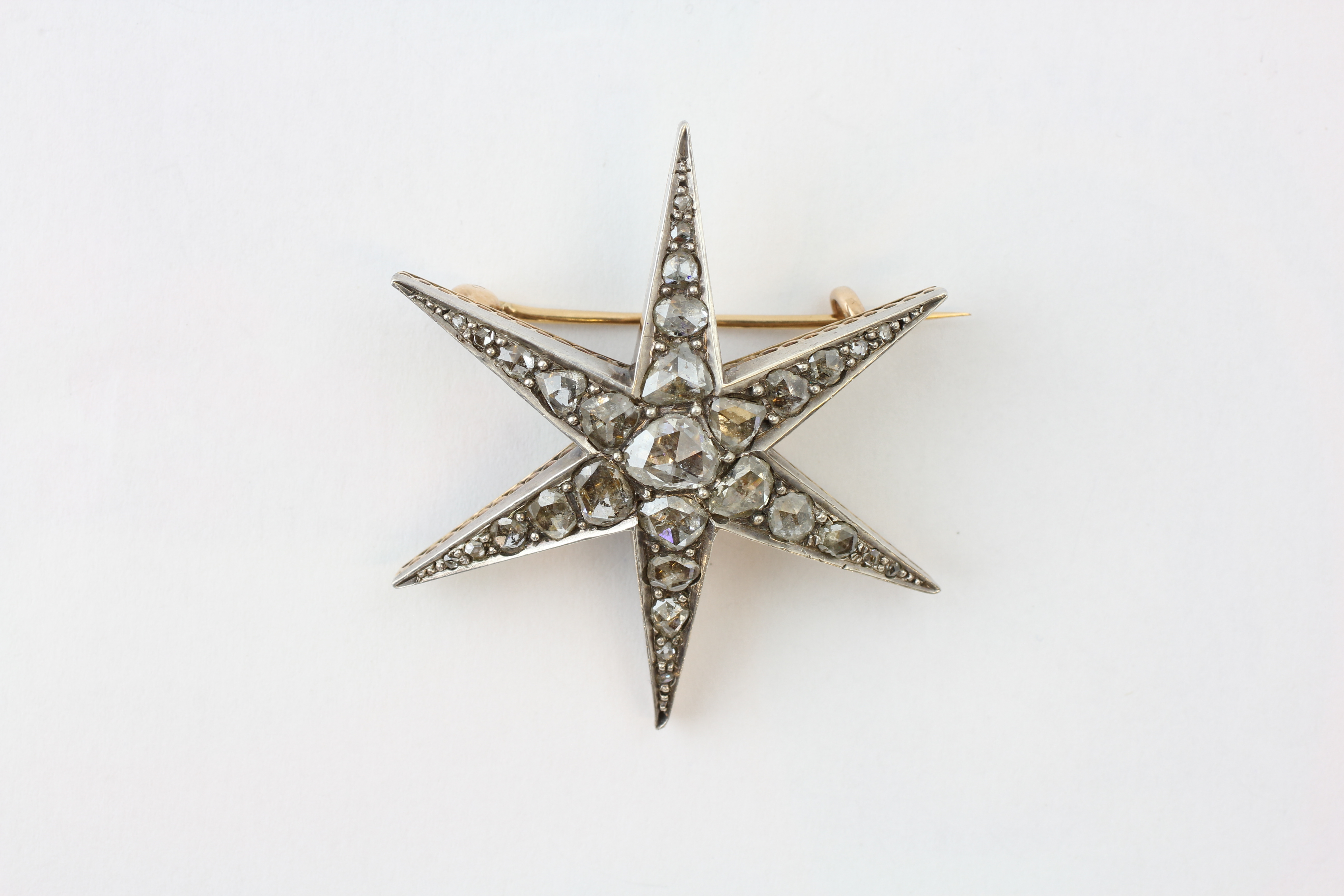 A DIAMOND BROOCH OF SIX-POINTED STAR DESIGN AND SET WITH 31 OLD CUT DIAMONDS, DIAMETER APPROX.