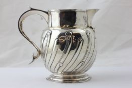 A GEORGE II PUNCH JUG, THE BODY WITH RIBBED AND SCROLLED DESIGN,