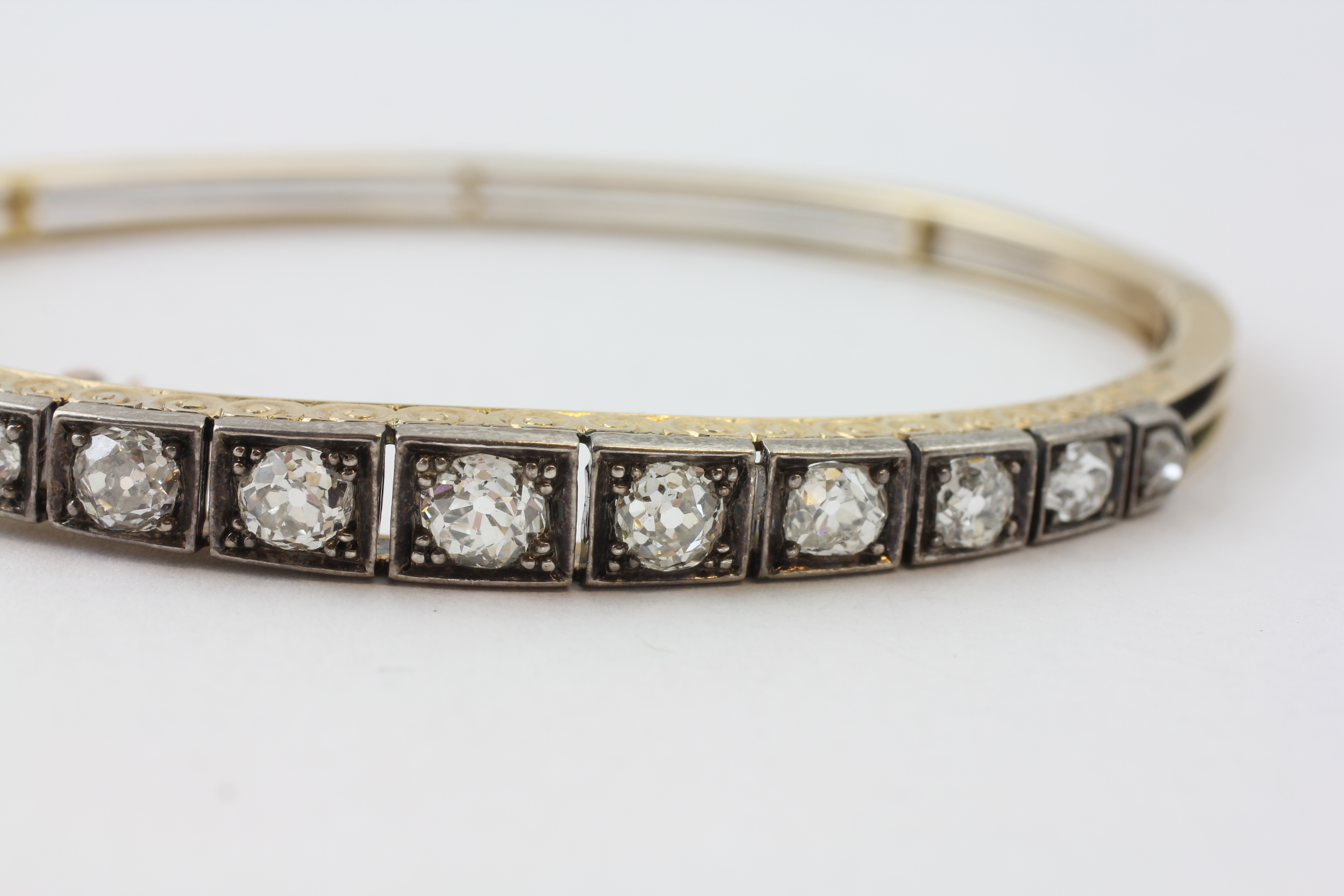 AN ELEVEN STONE DIAMOND HINGED BANGLE WITH SAFETY CHAIN, - Image 5 of 7