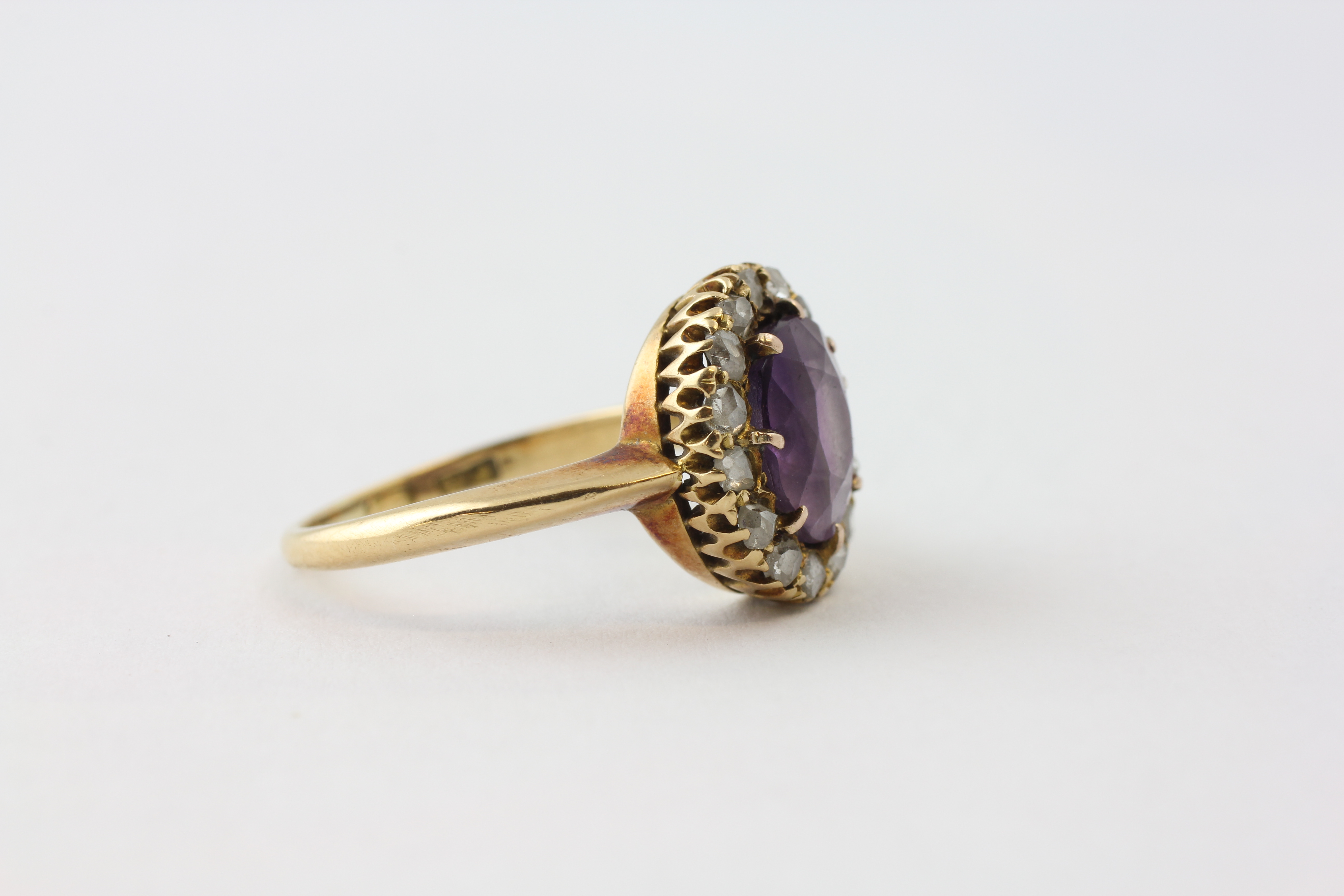 AN AMETHYST RING, THE OVAL STONE SURROUNDED BY FIFTEEN SMALL DIAMONDS SET IN YELLOW METAL, - Image 2 of 6