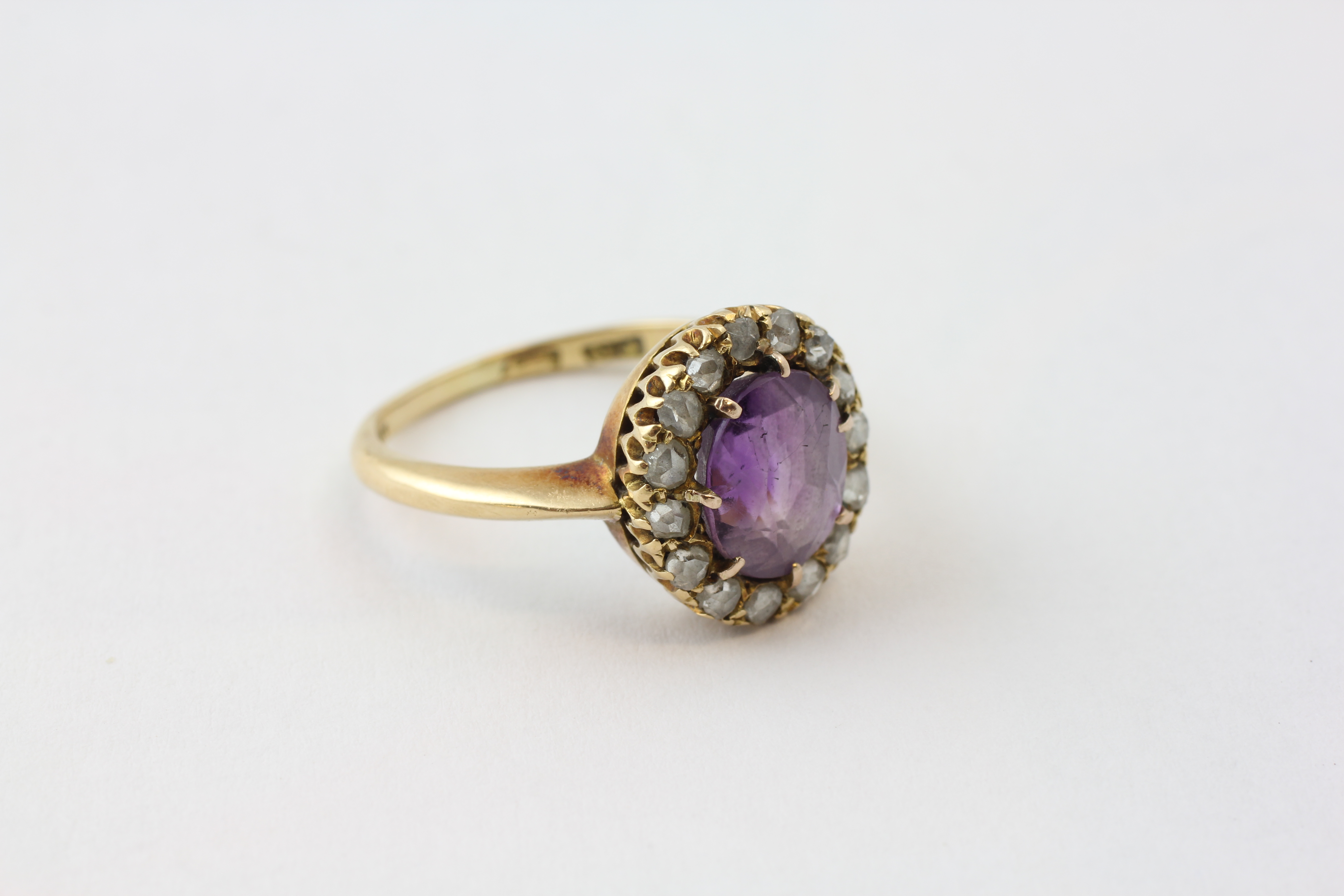 AN AMETHYST RING, THE OVAL STONE SURROUNDED BY FIFTEEN SMALL DIAMONDS SET IN YELLOW METAL, - Image 5 of 6