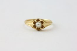 AN UNMARKED YELLOW METAL RING, CLAW SET WITH A SINGLE PEARL,