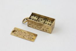 A YELLOW METAL CHARM IN THE FORM OF A PENDANT BOX CONTAINING THREE DICE,