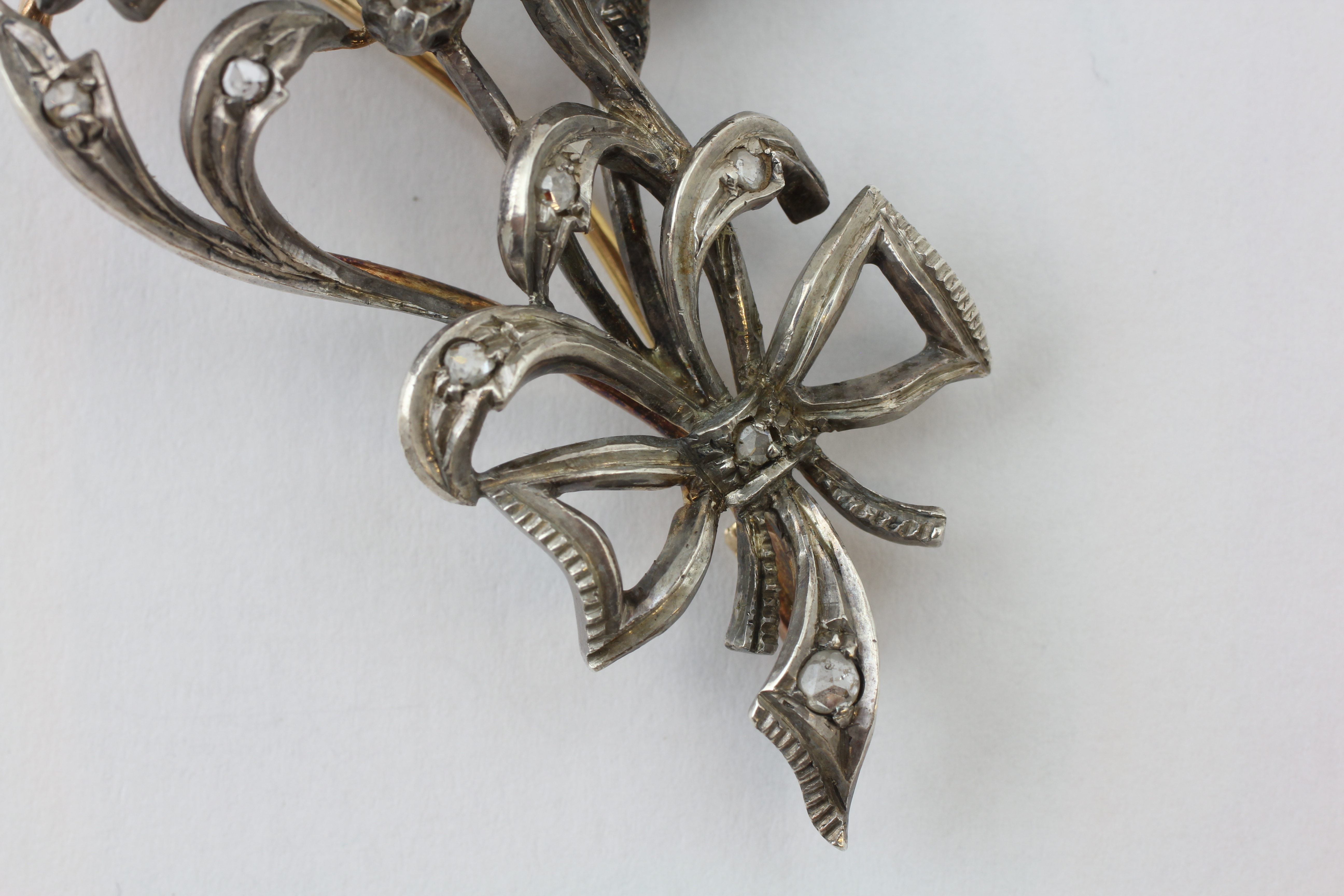 AN EDWARDIAN DIAMOND BROOCH OF FLOWERHEAD AND BOW DESIGN SET IN WHITE AND YELLOW PRECIOUS METAL, - Image 4 of 5