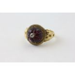 A VICTORIAN MOURNING RING, THE AMETHYST CABOCHON WITH FLUTES AND SURMOUNTED BY AN OLD CUT DIAMOND,