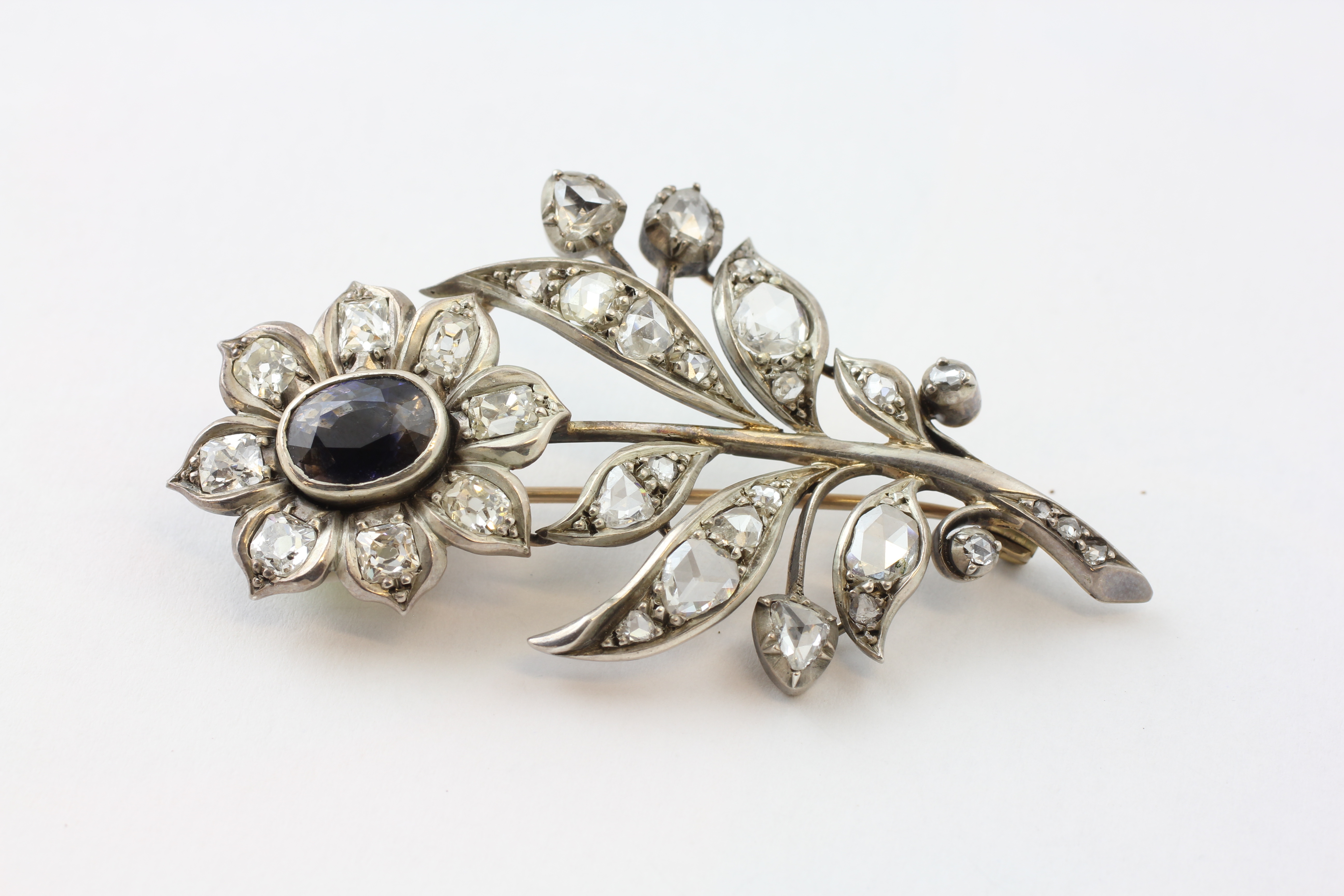 A SAPPHIRE AND DIAMOND BROOCH OF FLOWER DESIGN, SET WITH 36 OLD CUT DIAMONDS,