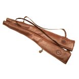 A PAIR OF LEATHER FLEECE-LINED SINGLE GUNSLIPS, both with leather shoulder strap and brass fittings,