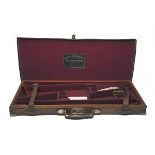 A BRASS-CORNERED OAK AND LEATHER DOUBLE GUNCASE, fitted for 30in. barrels, the interior lined with