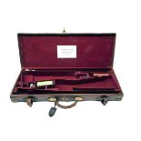 A BRASS-CORNERED LEATHER DOUBLE GUNCASE, fitted for 28in. barrels, the interior lined with maroon