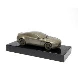 ANTHONY HOLT SILVERSMITHS A COLD CAST OF AN ASTON MARTIN DB9, mounted on a black plinth, measuring