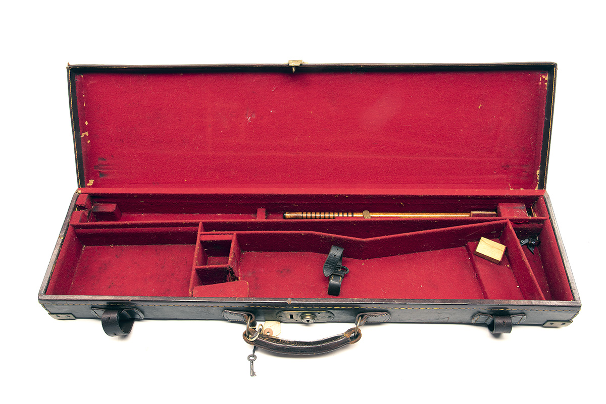 A BRASS-CORNERED LEATHER SINGLE GUNCASE, fitted for 30in. barrels, the interior lined with red