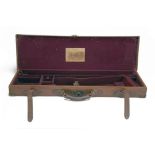 A BRASS-CORNERED LEATHER SINGLE GUNCASE, fitted for 28in. barrels, the interior lined with maroon
