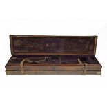A BRASS-CORNERED OAK AND LEATHER DOUBLE SIDED SINGLE GUNCASE, fitted for 31in. barrels, the interior