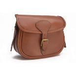 A TAN LEATHER CANVAS-LINED CARTRIDGE BAG, canvas and leather shoulder strap and brass fittings.
