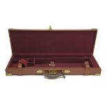 A BRASS-CORNERED LEATHER SINGLE GUNCASE, fitted for 26in. barrels, the interior lined with maroon