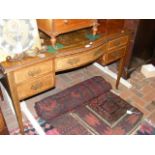 An Edwardian writing desk with brown leather top