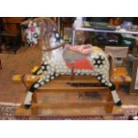 An antique painted wooden rocking horse, standing