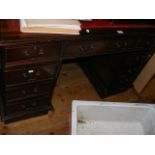 A reproduction pedestal desk with red leather top