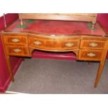 An Edwardian writing desk with red leather top