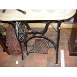 A marble top garden table with a cast metal sewing