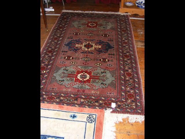 An antique Middle Eastern rug with geometric borde