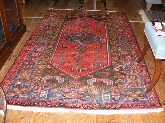 An antique Middle Eastern rug with geometric borde