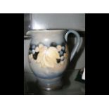 A Moorcroft Pottery jug with 'grape' design - 18cm