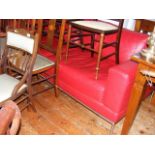 A red three seater settee with chrome feet