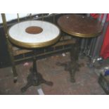 A pair of antique circular pub tables with decorat