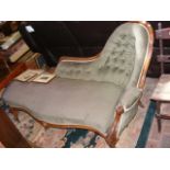 An antique chaise longue upholstered in sage green