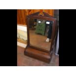 An antique hanging wall mirror in wooden frame and curved