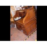 A roll-top desk with drawers below and fitted interior