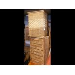 A cane laundry basket and wicker storage unit