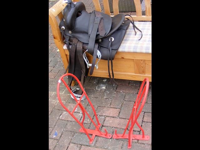 A leather horse saddle, together with two metal sa