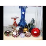 A cluster of glass paperweights and vases