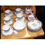 An assortment of teacups and plates, including Kok
