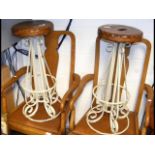 A pair of wrought iron bar stools with wooden seat