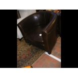 A brown leather style tub chair