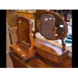 An oval dressing table mirror with three jewellery