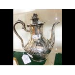 A silver coffee pot with raised decoration and London