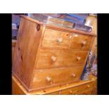 A small pine chest of drawers with two short and t