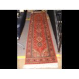 A Middle Eastern style runner with geometric borde