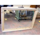 A large wall mirror in bare pine frame - width 104