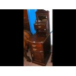 A narrow mahogany washstand