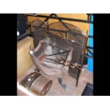 A wrought iron fire basket with tools, copper coal
