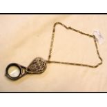 A 9ct gold chain with magnifying glass pendant, th