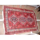 A Middle Eastern rug with red ground and geometric